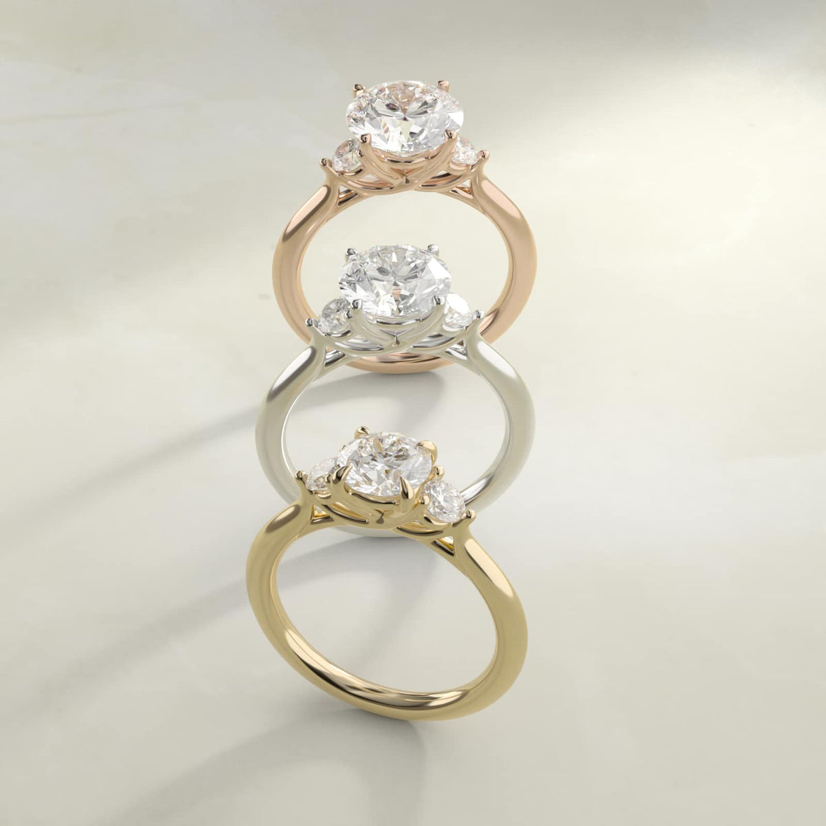 Three-stone moissanite engagement rings in silver, rose gold plated, and gold plated
